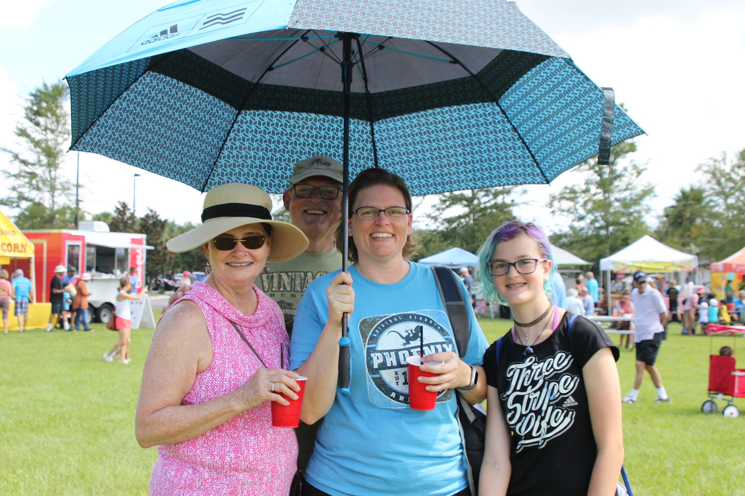Linda and Bill Foster were visiting daughter Sarah Leaf, holding the umbrella, and their granddaughter, Annabelle Leaf. Sarah just happened to have an umbrella in the car to keep the family cool while visiting the market.